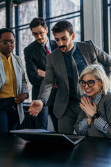 Teamwork in action. Businesspeople discussing ideas while working on a laptop