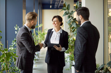 Company of corporate men and woman coworkers shaking hands during meeting, closing successful deal,...