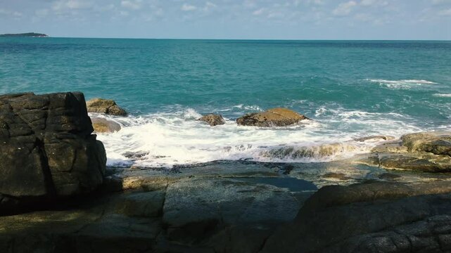 Water foams from impacts on rocks off the coast of the Gulf of Thailand