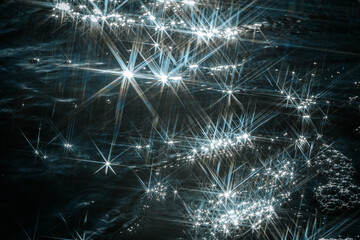 Fototapeta premium Sunlight reflects off flowing water, creating a dazzling starburst effect. The contrast between shimmering light and rushing currents adds a dynamic and mesmerizing feel to the scene.