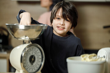 Mother and son are preparing a cherry cake together