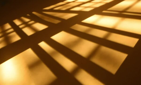 a prison cell  with  the sun  shining through the bars