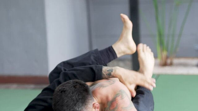  Two jiu-jitsu athletes demonstrating grappling and submission techniques