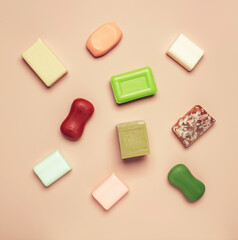 Assortment of colorful toilet moisturizing soap on pink background. Soft light, top view