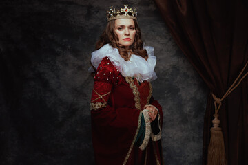 medieval queen in red dress with white collar and crown