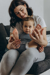 Two year old cute boy sitting in his mother arms,both smiling and enjoying a joyful moment together