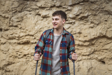 portrait of proud man hiker with raise hiking sticks after footpath