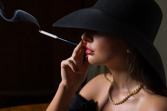 Lady in black hat with cigarette holder