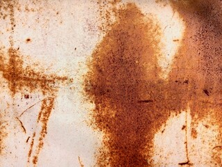 Close-up of a heavily rusted metal surface with brown and orange tones, man face form inside