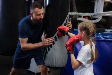 Obraz premium Boxing coach training girl in sport center
