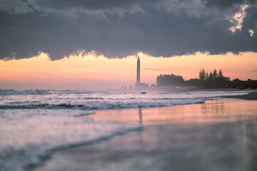Romantyczny zachód słońca nad morzem z latarnią morską i burzowymi chmurami © Adam.rtk