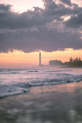 Romantyczny zachód słońca nad morzem z latarnią morską i burzowymi chmurami © Adam.rtk