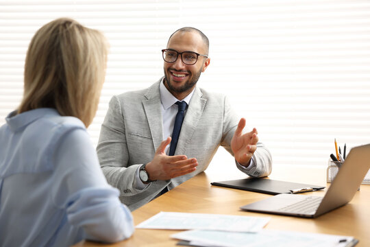 Coworkers working together at table in office