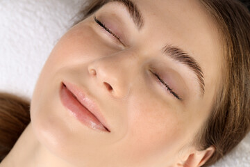 Beautiful woman after lash laminating and tinting procedure on white background, closeup