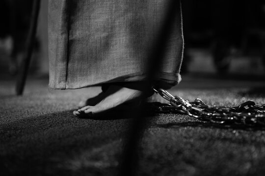 Close up of feet shackled in chain symbolizing penance in holy week