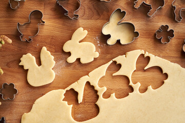 Cutting out animal shapes from raw pastry dough - preparation of homemade Linzer Easter cookies
