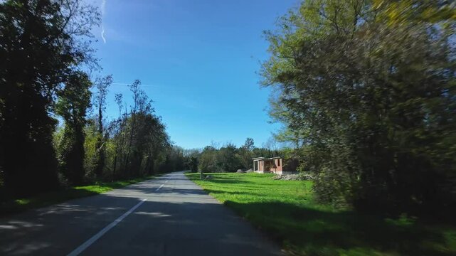 Driving on a country road through the Istria Peninsula surrounded with beautiful vegetation. Peaceful street with amazing green plants and construction work of a half-hearted house. Balkan lifestyle.