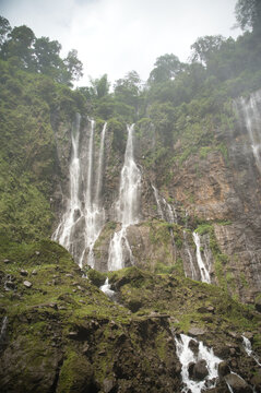 Majestic Tumpak Sewu Waterfall surrounded by lush greenery