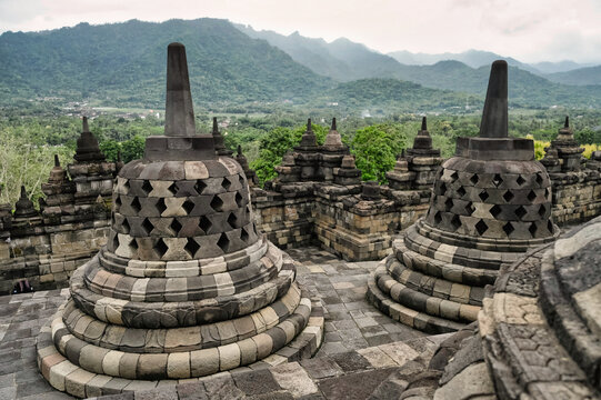 Ancient Borobudur Temple stupas against mountain backdrop