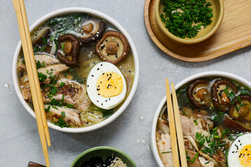 Ramen soup with chicken, shiitake mushrooms, spinach and egg in bowls .style hugge