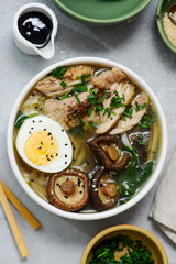 Ramen soup with chicken, shiitake mushrooms, spinach and egg in bowls .style hugge