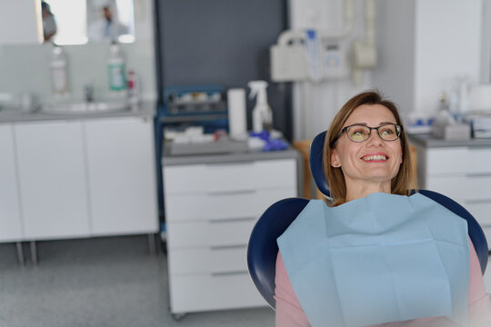 A woman in dentist chair during her annual ceck up in dental clinic.