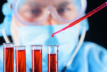 Blood test. Doctor works with patient's blood sample in lab. Drop of blood on pipette, selective...