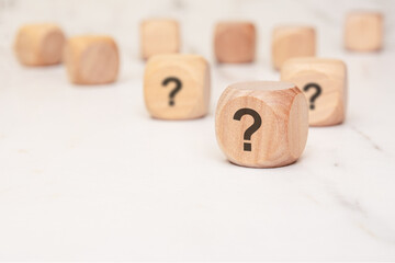 wooden blocks with question marks symbolizing uncertainty, decision-making, and strategic choices