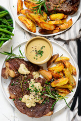 steak with  sauce and potatoes.
