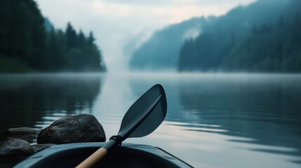 Serene morning on a misty lake with a kayak paddle resting on the edge, surrounded by nature