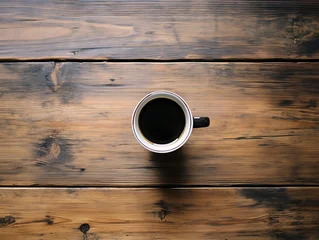 A single mug filled with black coffee sits on wood planks