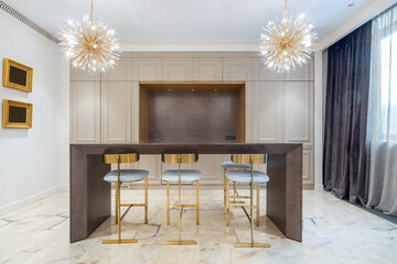 Modern kitchen interior design with beautiful ceiling lights. A high table with bar stools.