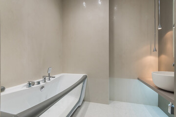 Exclusive bathroom design. A bathtub with a transparent wall. Stylish lamps.