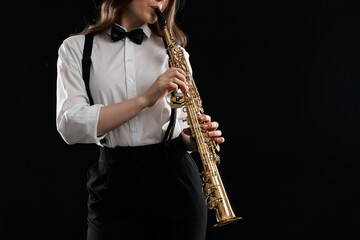 Naklejka premium Musician playing soprano saxophone on dark background, closeup