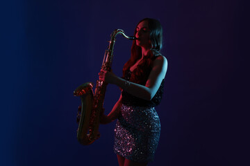 Professional musician playing saxophone on color background