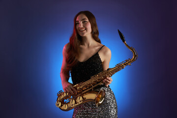 Naklejka premium Professional musician with saxophone on color background