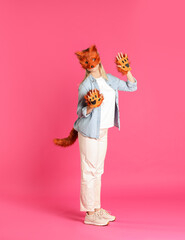 Quadrobics. Woman wearing fox mask, gloves and tail on pink background