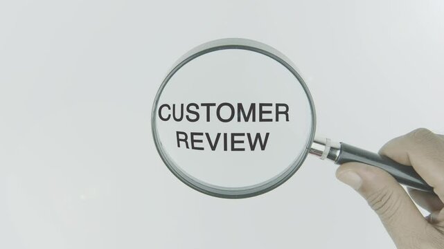 Customer review word or text highlighted by a magnifying glass in a hand on a white background, symbolizing feedback, ratings, and service evaluation