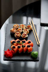 Sushi set on a black background. Sushi roll with salmon, caviar, cream cheese and wasabi.