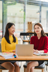 Obraz premium Asian Women Collaborating on Laptop