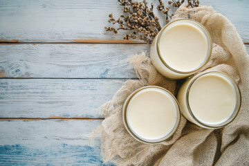 Soy milk bottles resting on rustic burlap sack and wooden table