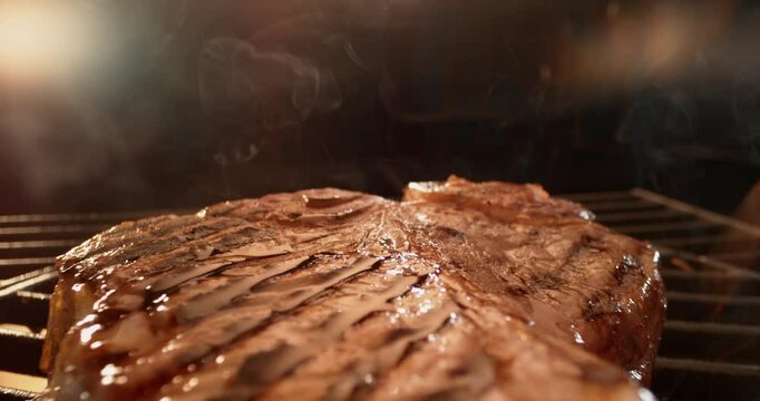 Close-up view of a perfectly grilled T Bone steak sizzling on a hot barbecue grill