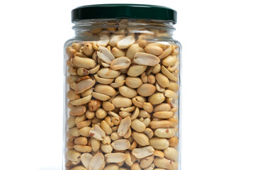 Glass jar with green lid filled with peanuts on isolated white background. Close up of snack peanut filled jar. Nutrition, storage, health and vegetarian concept. Copy space