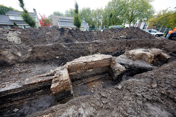 Excavation of ancient city walls revealing historical foundation in urban area