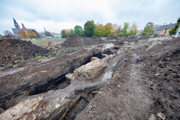 Excavation of ancient city walls unearths historical structures in a urban area