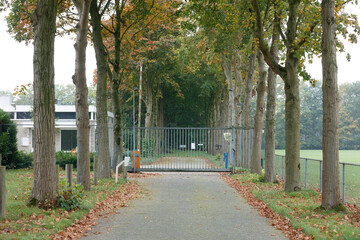 Abandoned asylum seeker center in the Netherlands surrounded by trees and a gated entrance