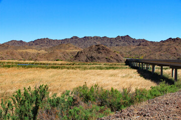 Bill Williams Memorial Bridge in Bill Williams River National Wildlife Refuge near Lake Havasu and Colorado River near Lake Havasu City, Arizona, USA with view of California and blue sky copy space.