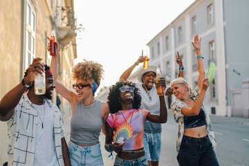 Cheerful friends celebrating with drinks at summer festival