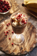 A cup of homemade chia chocolate pudding with fresh bananas