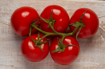 tomatoes on a branch, five fruits, top view against an old board